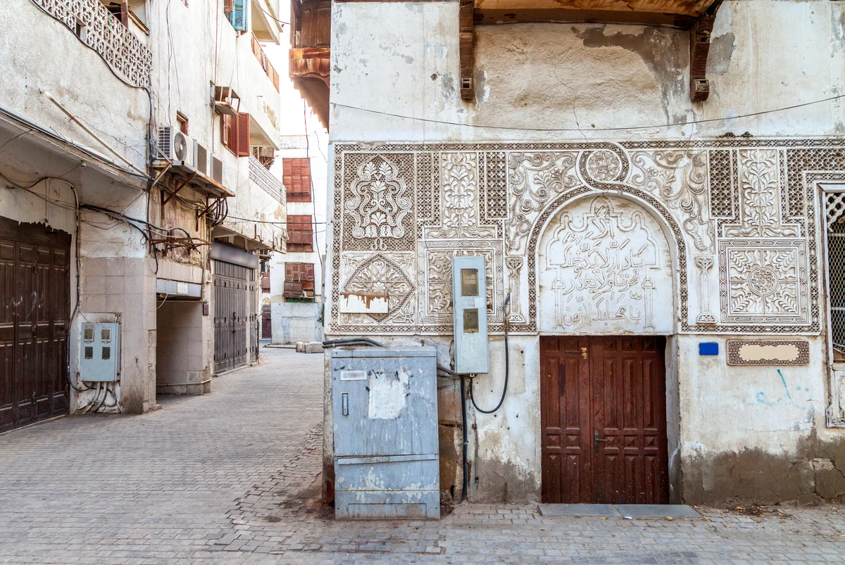 A historic coral-stone house in Al-Balad, old Jeddah, with carved plaster and a wooden door